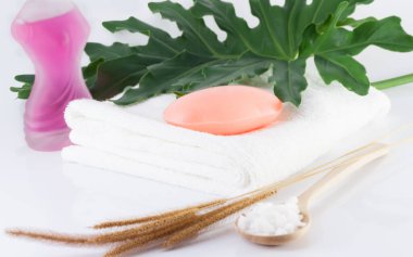 Temiz beyaz havlulara sabun, yeşil yapraklar ve hijyen için beyaz sahnelere tuz sür..