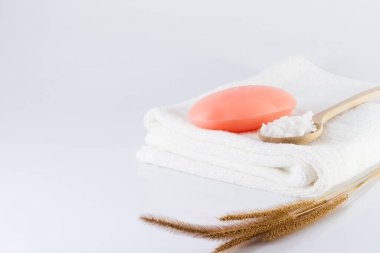 Bir kalıp sabun ve temiz beyaz havlu hijyen için beyaz bir sahnede..