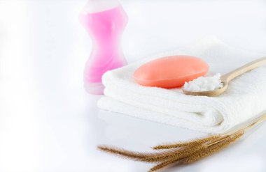 Bir kalıp sabun ve temiz beyaz havlu hijyen için beyaz bir sahnede..
