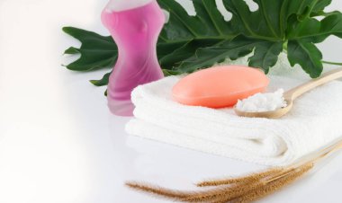 Temiz beyaz havlulara sabun, yeşil yapraklar ve hijyen için beyaz sahnelere tuz sür..