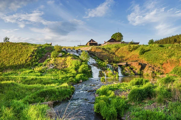 Beautiful rural landscape with waterfall. Waterfall on the river Glinka, in the sunset.Russia. Urals