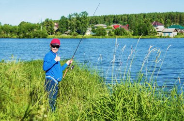 İplik ile neşeli kadın göl kıyısında yaz günde durumda.