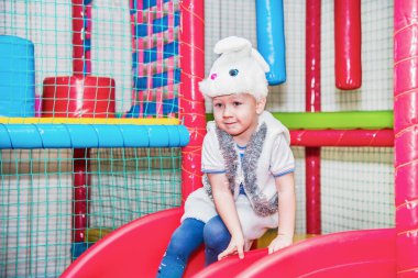 Çocuk eğleniyor. Çocukların oyun odasındaki kaydırağın oraya gidiyor.