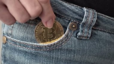 Atış bir kadının Bitcoin cryptocurrency bozuk para onun açık kot cebine koyarak kapatın.