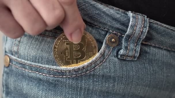 特写镜头的女人把比特币加密硬币到她的前牛仔裤口袋 — 图库视频影像