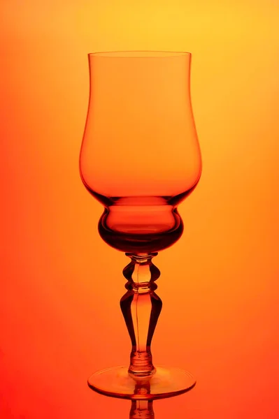 Transparent glass wine glass on orange background — Stock Photo, Image