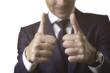 Kostümlü genç iş adamı beyaz arka planda işaret jesti kadar başparmak gösteren