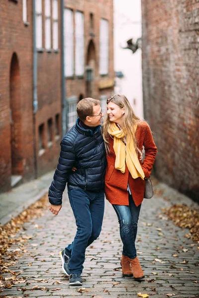 喜欢在老城区散步的情侣 一对情侣悠闲地漫步在凉爽的秋天早晨在吕贝克 的街道上 那家伙抱着他的妻子 — 图库照片