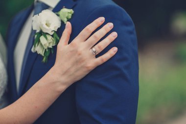 Gelinin eli damadı kucaklıyor.