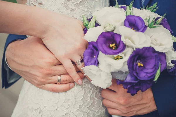 The bride and groom hold their hands with rings over a wedding b — Stock Photo, Image