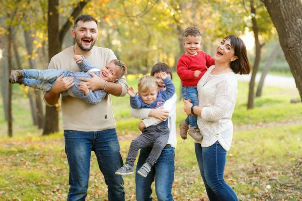 Lovely big family with four cheerful sons are playing on yellow — Stock Photo, Image