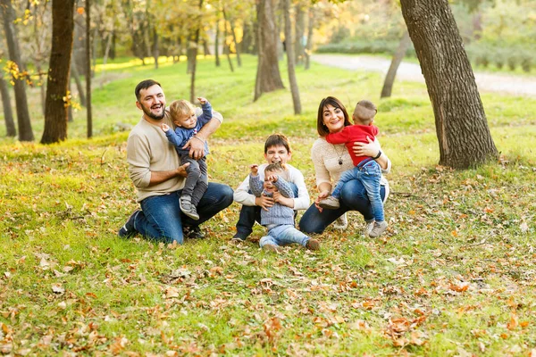 Bonita familia grande con cuatro hijos alegres están jugando en amarillo. — Foto de Stock