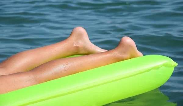 海の緑の空気マットレスの上の裸の足 クローズアップ 海によるホリデーシーズン — ストック写真