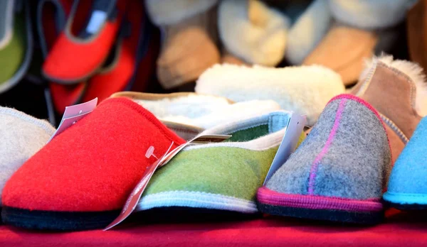 Many different colored warm slippers made of felt want at a stall at the christkindlmarkt