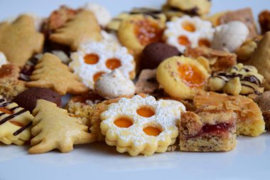 Beyaz tabakta bir sürü farklı Noel kurabiyesi ve koyu ahşap masa - arka plan ve doku