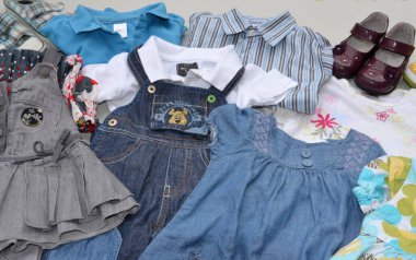 Used baby and children's clothes for resale at a used goods market clipart