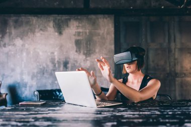 3 boyutlu izleyici kullanan genç ve güzel bir kadın. Fütürist, teknoloji, simülatör konsepti.