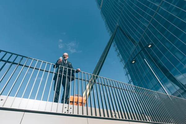 Zeitgenössischer Geschäftsmann Mittleren Alters Lehnt Einem Geländer Mit Smartphone — Stockfoto