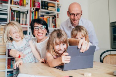 Tablet kullanan üç çocuklu aile - beraberlik, teknoloji, eğlence konsepti