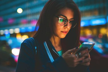 ekran ışıkla aydınlatılmış smartphone yüz kullanarak gece genç kadın karışık yarış 