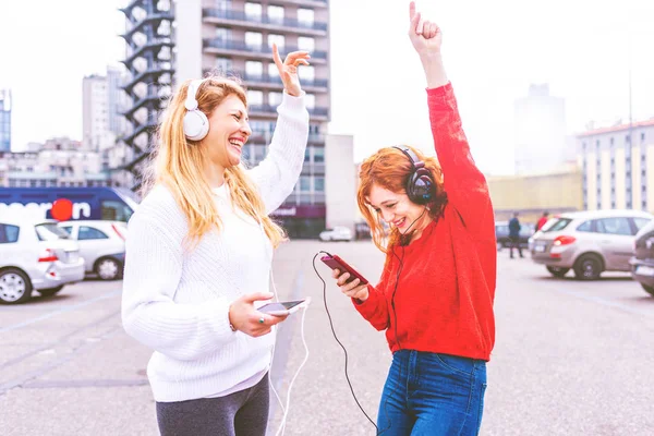 Dwie Młode Kobiety Taniec Słuchania Muzyki Smartfona Mieście — Zdjęcie stockowe