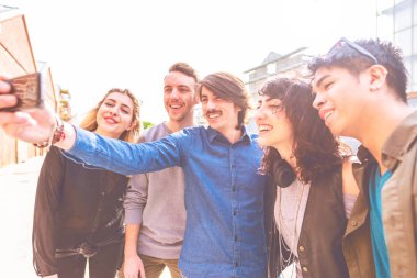Arkadaşlar millennials selfie alarak smartphone kullanarak Grup