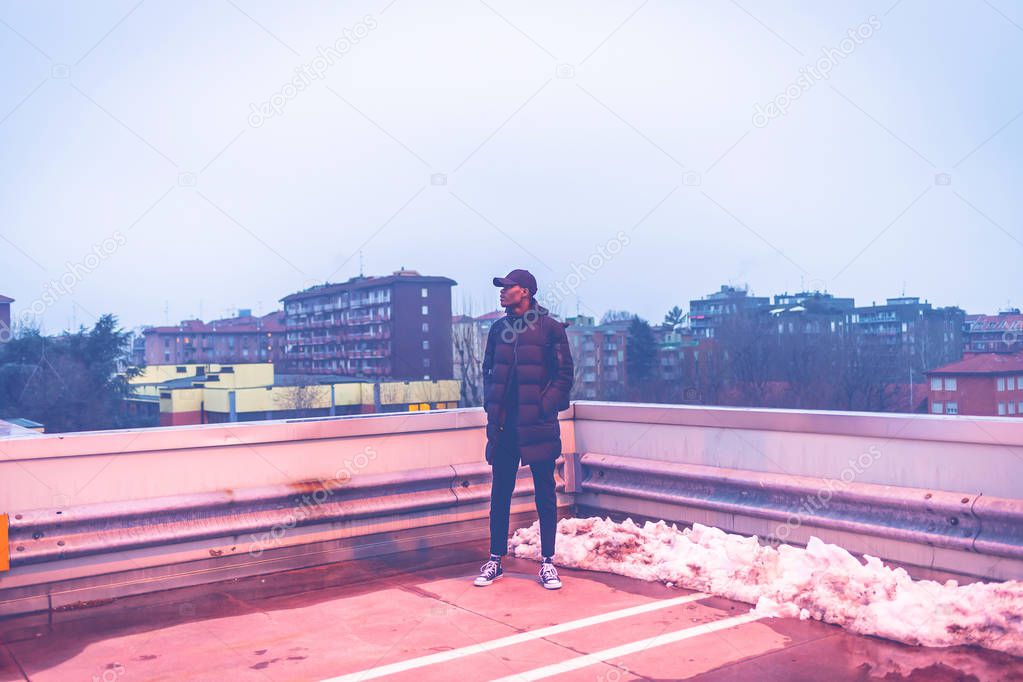 young african man outdoors posing parking lot looking away - rebel, rude boy, swag concept