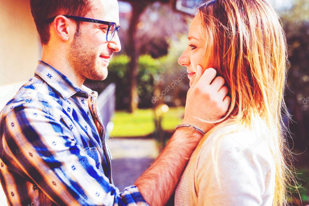 young couple in love outdoor back light looking in the eye serene - love, relationship, couple concept