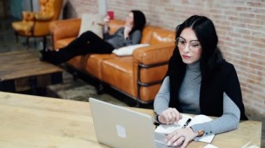 Genç, güzel bir kadın bilgisayar başında oturuyor. Masa başı işi, teknoloji, buluşma konsepti.
