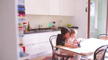 4k. Anne ve kızı tablet öğrenme, eğlence ve öğretim konseptini kullanarak kapalı alandalar.