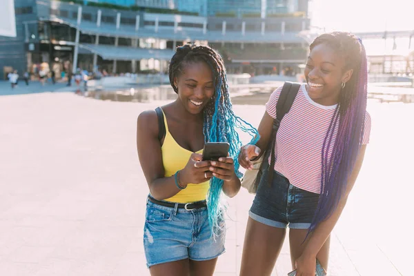 2人の女性姉妹屋外スマートフォンを使用して楽しい ソーシャルネットワークの概念 — ストック写真