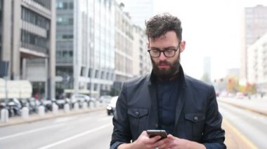 Akıllı telefon kullanarak şehirde genç sakallı Kafkas adam portresi 