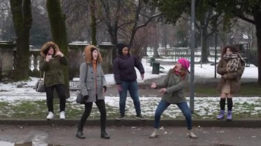 Ağır çekimde beş genç kadın çoklu etnik çeşitlilikte kar tarlasında dans ediyor. Mutluluk, dostluk, pozitif duygu kavramı.