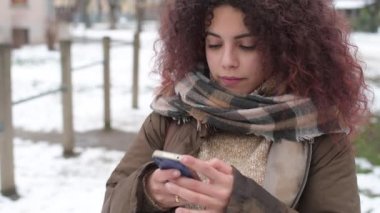 Ağır çekimde güzel bir kadın akıllı telefon kullanıyor kameraya bakıyor gülümseyen teknoloji, sosyal ağ, iletişim konsepti