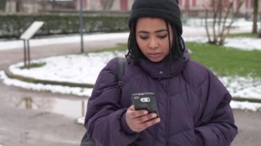 Ağır çekimde güzel bir kadın akıllı telefon kullanıyor kameraya bakıyor gülümseyen teknoloji, sosyal ağ, iletişim konsepti