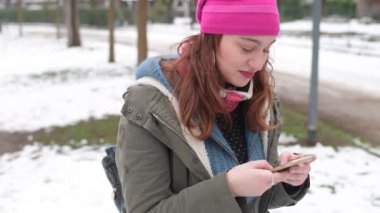 Ağır çekimde güzel bir kadın akıllı telefon kullanıyor kameraya bakıyor gülümseyen teknoloji, sosyal ağ, iletişim konsepti