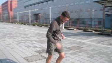 Genç adam şehirde açık hava eğitimi alıyor. Egzersiz, sağlıklı yaşam tarzı, spor anlayışı.