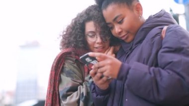 Akıllı telefon sosyal ağı, kablosuz teknoloji, kablosuz iletişim konsepti kullanan iki genç kadının yavaş çekimleri