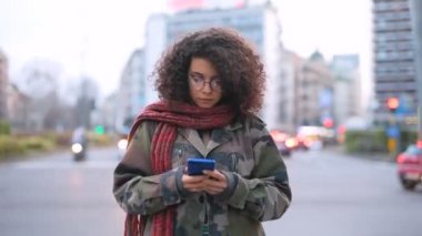 Akıllı telefon hatları, sosyal ağ, kablosuz iletişim konsepti kullanarak zaman aşımına uğramış çok ırklı genç bir kadın.