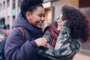 Sokakta sarılan iki genç kadın.