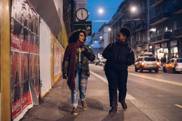 Duas garotas morenas e encaracoladas andando na rua — Fotografia de Stock