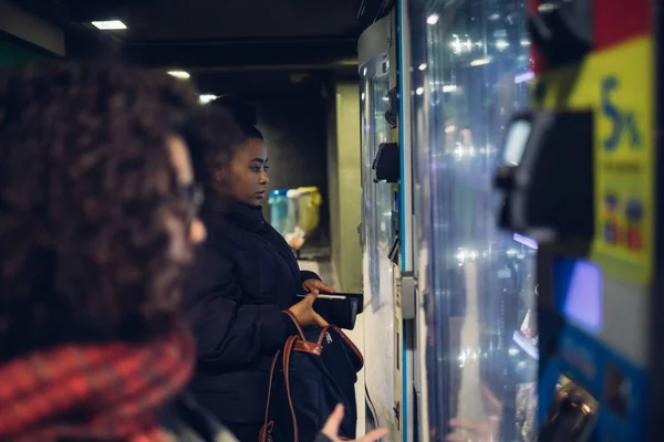 Zwei junge brünette Mädchen suchen Automaten — Stockfoto