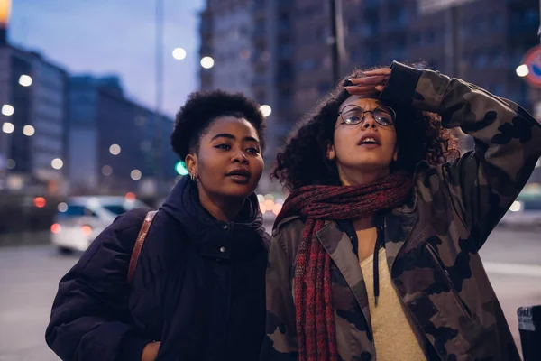 Дві молоді дівчата дивляться вперед у місті — стокове фото