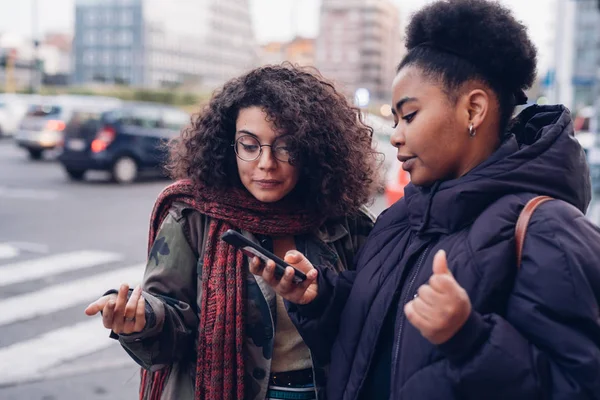 Dua gadis kulit hitam muda menggunakan smartphone di kota — Stok Foto