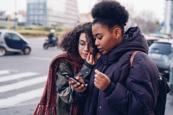 Dua gadis muda berselancar di internet dengan smartphone — Stok Foto