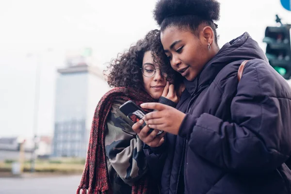 Dua gadis muda menggunakan smartphone di kota — Stok Foto