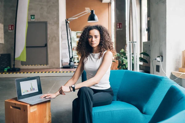 Jong krullend vrouw zitten met laptop — Stockfoto