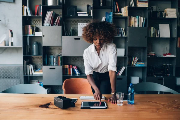 Fiatal fekete nő használ tabletta a modern irodában — Stock Fotó