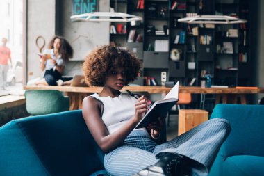 Modern açık alanda yazan ve çalışan iki çok ırklı genç kadın.