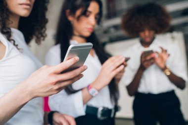 Akıllı telefon ile veri etkileşimi ve paylaşımı yapan üç genç iş kadını
